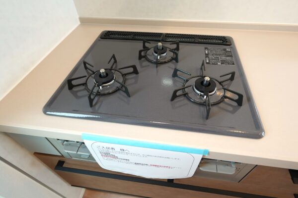 三口コンロを備えたガスコンロ。広いトッププレートで調理がしやすく、シンプルで清潔感のあるデザインがキッチンに調和します。(キッチン) 三口コンロを備えたガスコンロ。広いトッププレートで調理がしやすく、シンプルで清潔感のあるデザインがキッチンに調和します。(キッチン)